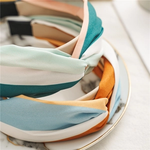 Close-up of knotted fabric headbands featuring orange, blue, and white stripe patterns