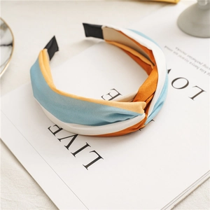 Detail of twisted fabric headband in blue, orange and white on a lifestyle magazine