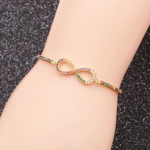 Detailed shot of infinity bracelet with colorful zircons on gold chain for women and men