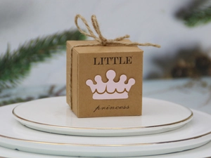 Détail de boîte cadeau en papier kraft avec couronne rose et nœud en corde de jute