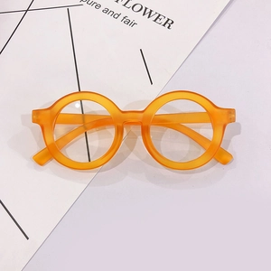 Macro detail of vibrant orange round children's glasses with matte frosted texture