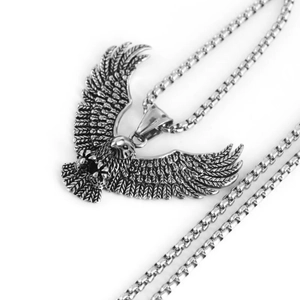 Macro detail showing vintage eagle pendant with intricate feather texture and box chain