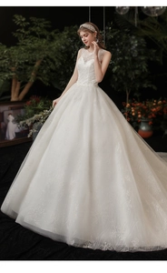 Detail of white bridal gown featuring intricate lace embroidery and sequined floral patterns