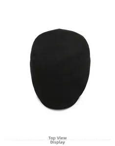 Top down view of black cotton twill flat cap showing fine fabric texture and minimalist style