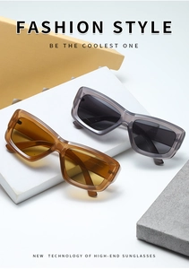 Detail view of stylish thick frame sunglasses in amber and smoky gray on geometric blocks