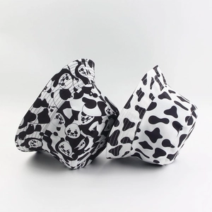 Détail des bobs réversibles en toile de coton avec motifs de panda et imprimé vache