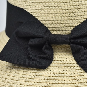 Women's summer straw sun hat with elegant black ribbon bow featuring UV protection