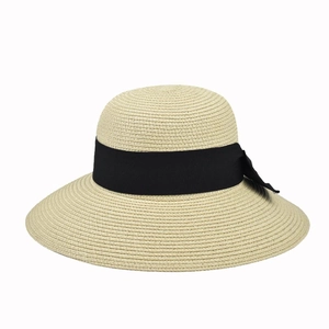 Detailed view of the beige straw hat weave with elegant black ribbon and bow accent