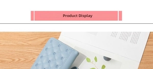 Detail of light blue quilted long wallet with crown embroidery on wood background