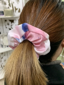 Close-up of pink and blue tie-dye scrunchie showing fabric texture on ponytail
