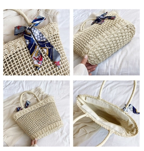 Detail view of woven straw bag with floral silk scarf and zip lining interior