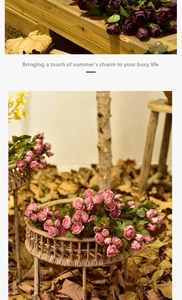 Detail of vintage style artificial roses in purple and pink with green leaves