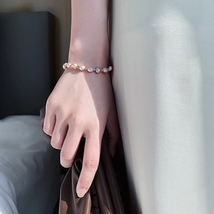 Detail of natural freshwater pearl bracelet with gold metal beads on a woman's wrist