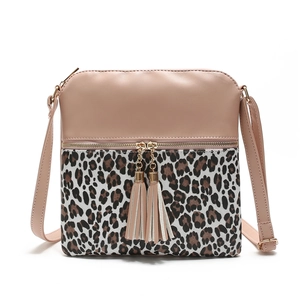Crossbody bag with leopard print stitching and dual tassel pendants on white background