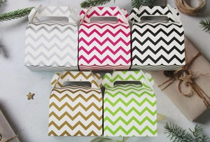 Top view of five colorful chevron patterned cake boxes with handles in festive setting