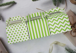 Flat lay of three green and white geometric patterned Halloween bakery gift boxes