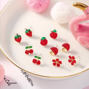 Detail view of colorful fruit earring set with strawberry apple and floral motifs