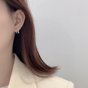 Close-up of a model wearing minimalist silver square geometric earrings in a modern style