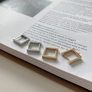 Detailed view of square geometric S925 sterling silver earrings in gold and silver