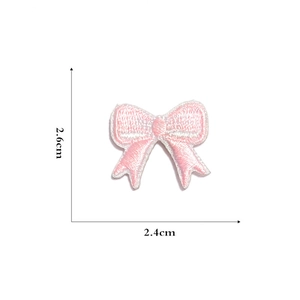 Close-up of pink bow embroidery patch with white edges and 2.4cm x 2.6cm dimensions
