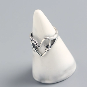 Macro detail of 925 sterling silver handmade heart ring on a marble display stand