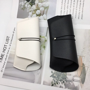 Detail of premium lychee texture leather eyewear pouches in black and white colors