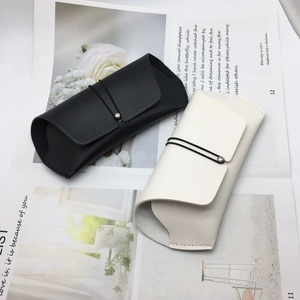 Detail of premium lychee texture faux leather glasses cases in black and cream beige
