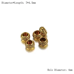 Détail macro de perles d'espacement dorées 7x4,5mm avec trou 4mm et motif gravé