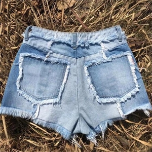 Détails d'un short en jean bleu clair avec ourlet effiloché à franges et fini délavé
