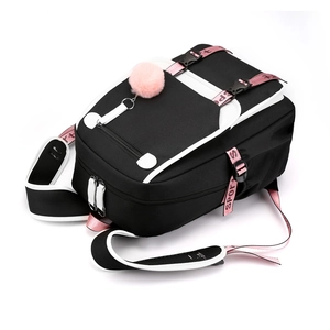 Black Oxford backpack with pink ribbon straps and plush ball charm in a studio shot