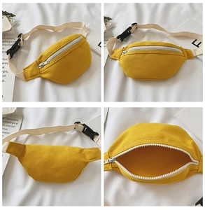 Detail view of yellow canvas kids fanny pack with adjustable strap and plastic buckle