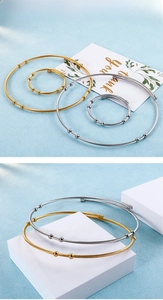 Detail of twisted cable wire jewelry set with gold and silver beads on a blue texture