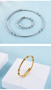 Detailed view of woven metal jewelry set in silver and gold on a geometric background