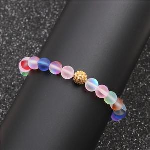 Bracelet en perles dépolies arc-en-ciel avec une perle pavée dorée sur un support noir