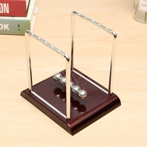 Overhead view of a Newton's cradle with five silver metal balls on a mahogany wood base