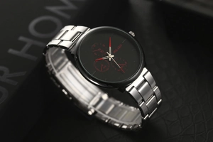 Detailed close-up of three-eye black dial quartz watch with red hands and silver steel band