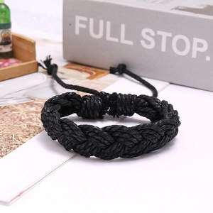 Detail of hand-woven black rope bracelet with adjustable knot on a white background