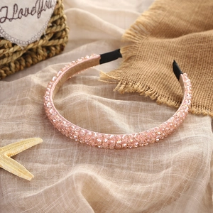 Close-up of pink crystal beads on a thin headband with soft fabric wrapped ends