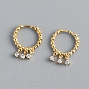 Close-up of gold S925 sterling silver hoop earrings with three dangling cubic zirconia