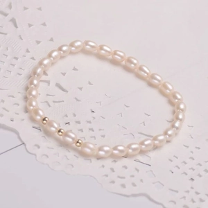 Elegante bracciale di perle naturali d'acqua dolce con perline d'oro su pizzo bianco