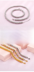 Detailed macro view of beaded stainless steel necklace and bracelet set in silver and gold