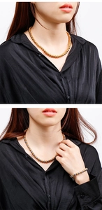 Close-up of model wearing gold and two-tone steel bead necklace and bracelet set