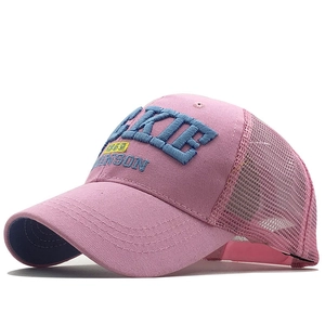 Détail de casquette trucker rose avec broderie 3D et visière courbée sur fond blanc