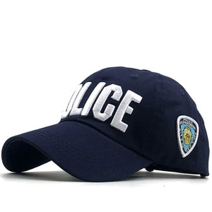 Detail of white POLICE embroidery and NYPD-style shield patch on navy blue baseball cap