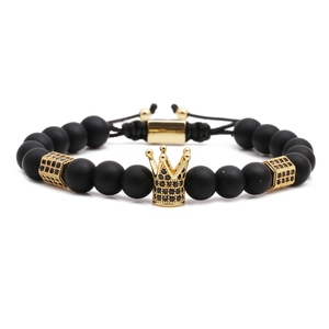 Bracelet pour homme en perles noires mates avec une couronne dorée sur fond blanc