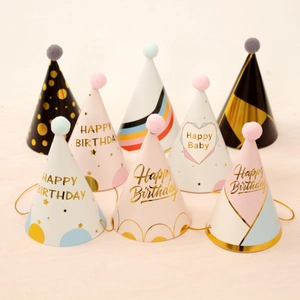 Row of colorful cone party hats with soft pom-poms and golden birthday lettering