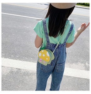Outdoor shot showing back view of child wearing yellow mushroom crossbody bag