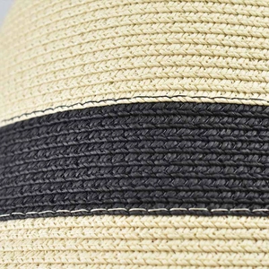 Macro detail of beige and black striped straw woven texture for women's summer sun hat
