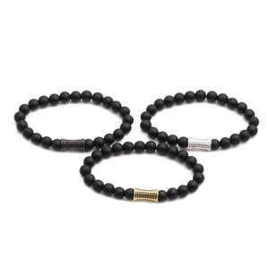 Bracelets en perles de pierre noire mate avec charmes cylindriques en trois finitions métal