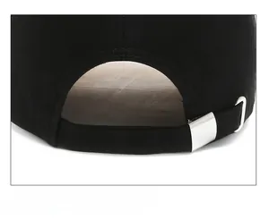 Detail of adjustable metal buckle and strap on back of black cotton baseball cap
